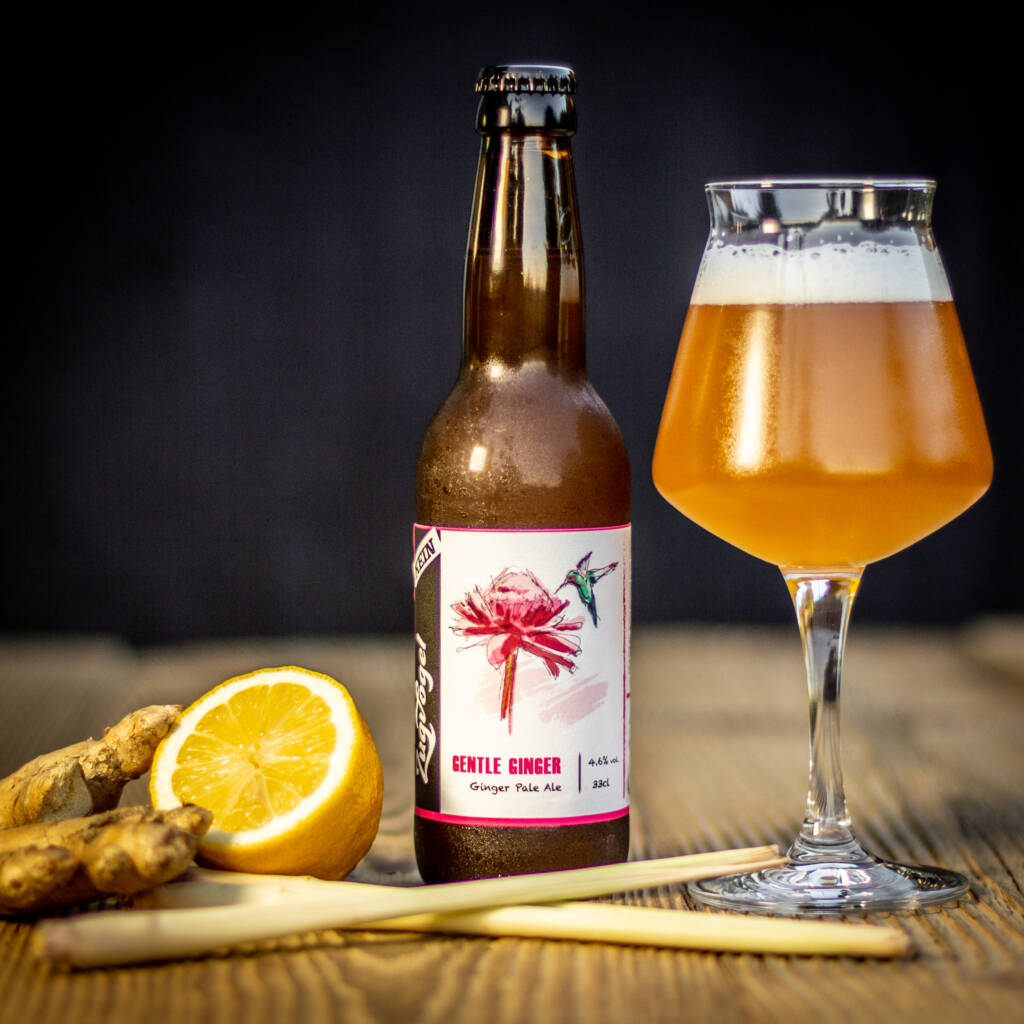 Foto einer Flasche Fond Blond mit einem Glas rechts und Orangen, Koriander und Weizen im Vordergrund